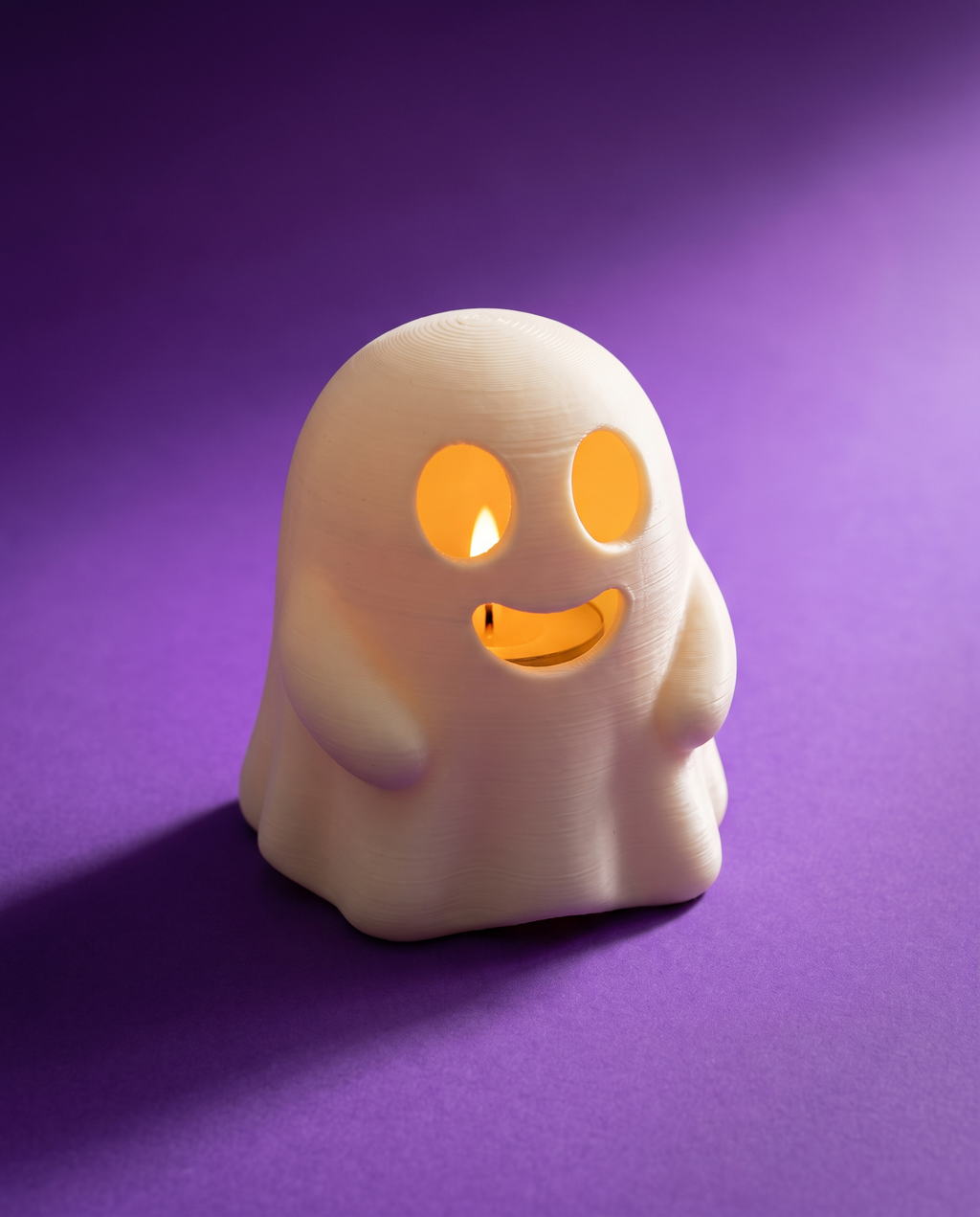 Portavelas con forma de fantasma sonriente encendido con luz cálida