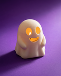 Portavelas con forma de fantasma sonriente encendido con luz cálida