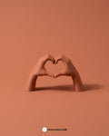 Manos en Corazón, vista principal sobre fondo tonal