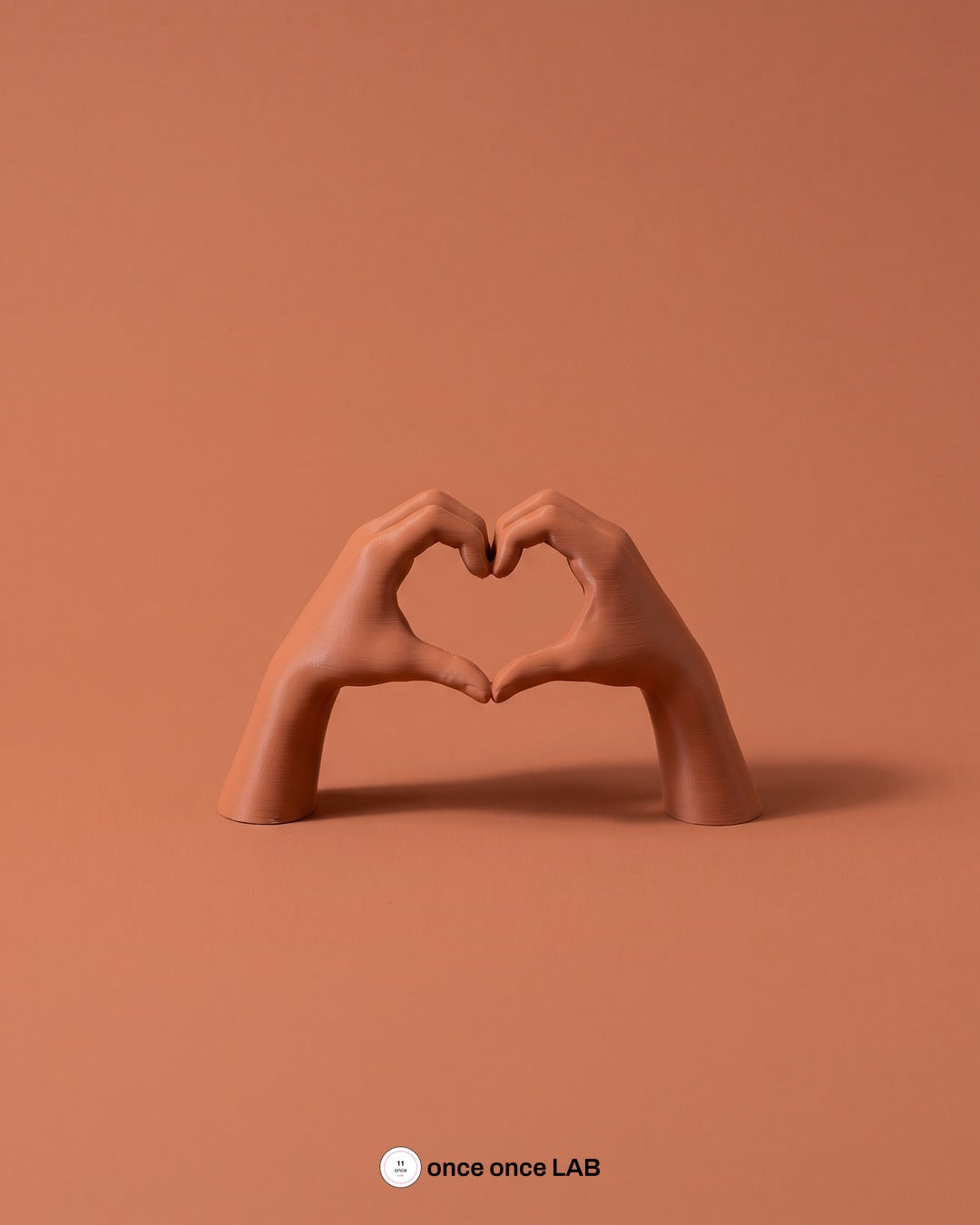 Manos en Corazón, vista principal sobre fondo tonal